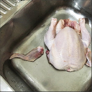 One wing removed at the elbow joint; chicken is breast-side up.