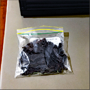 Pieces of beef jerky in a ziplock bag.